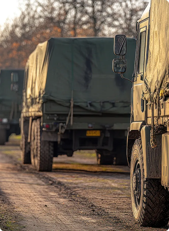 Military & Defense Trucks Driving Down Dirt Road